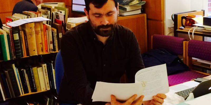 Photo of Tom Campbell reading documents in the Bauman Archive