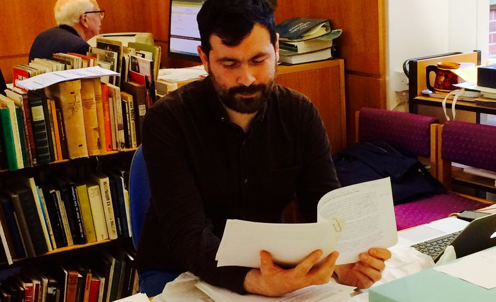 Photo of Tom Campbell reading documents in the Bauman Archive
