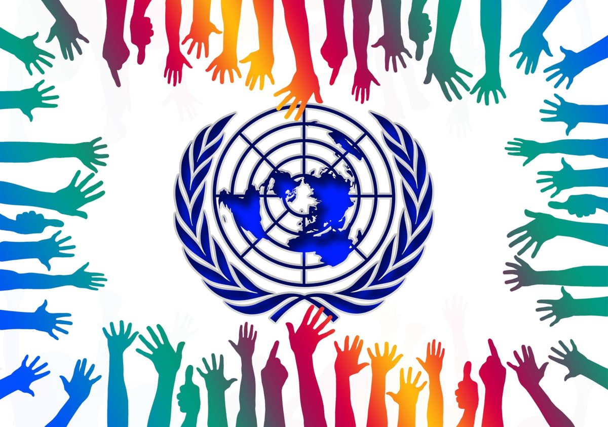Symbol of UN, surrounded by many multicoloured hands
